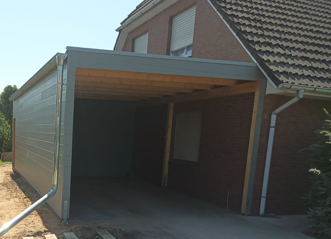 Freistehendes Carport aus Holz neben einem Wohnhaus