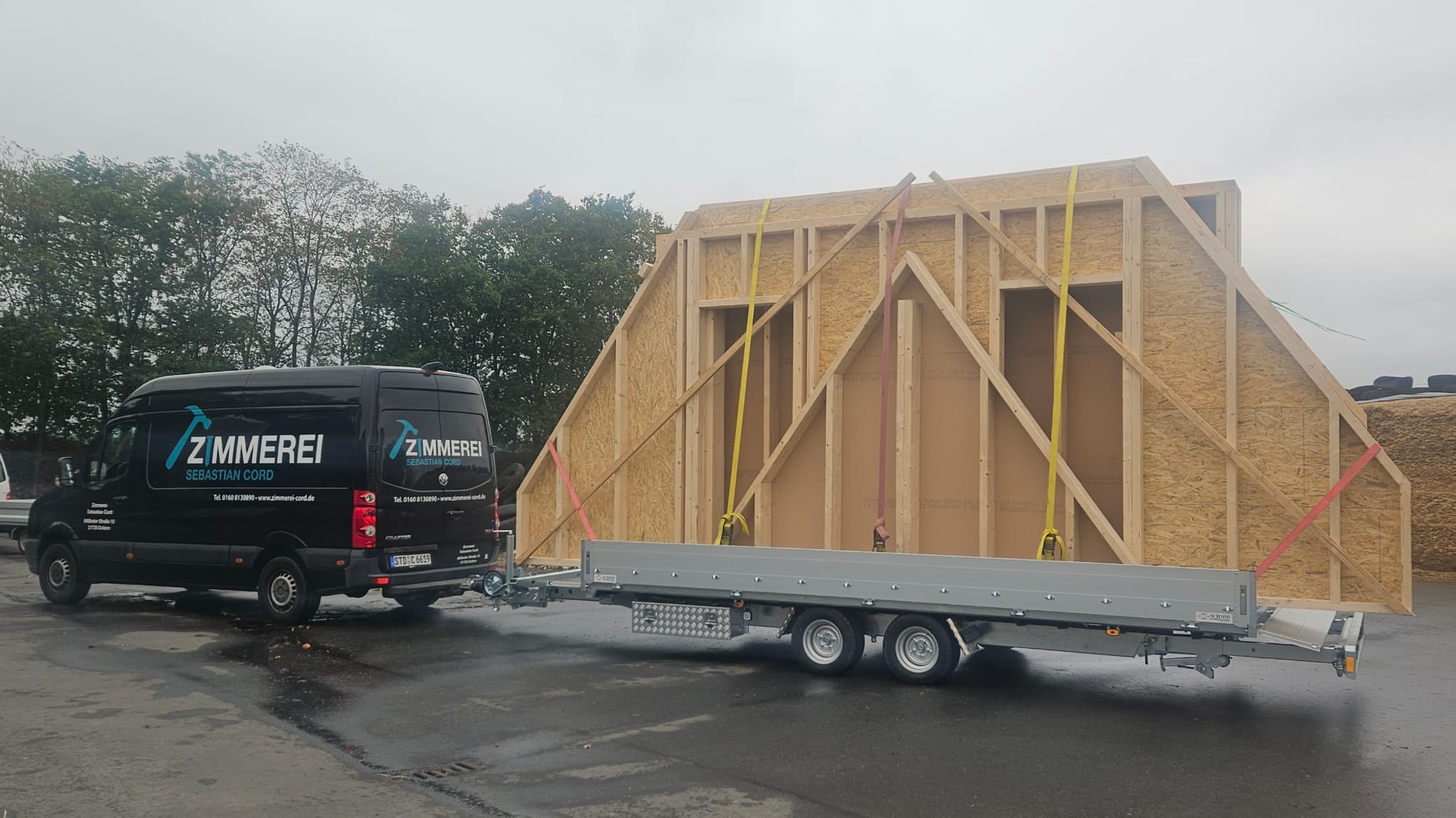 Firmentransporter mit vorgefertigtem Holzrahmenbau-Giebel auf dem Anhänger